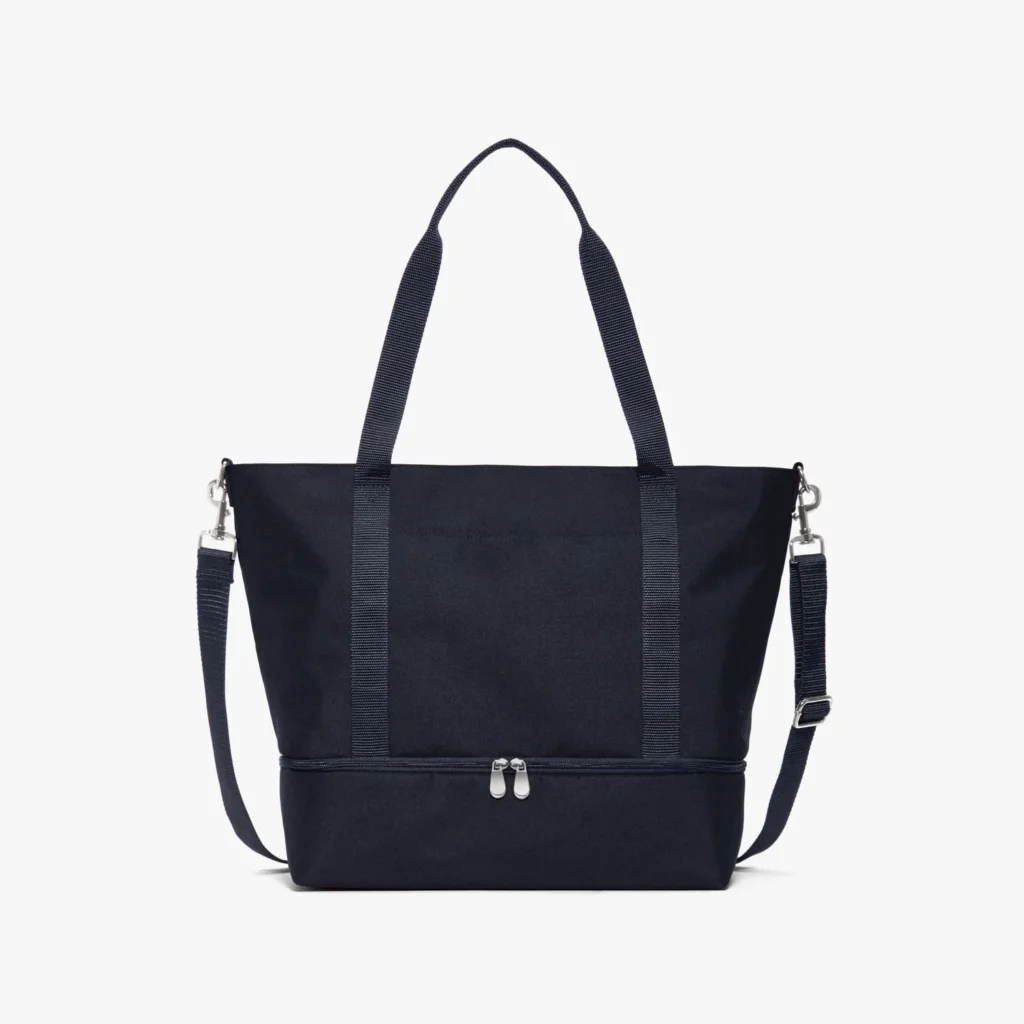 Navy Lo & Sons Catalina Deluxe Tote bag with shoulder strap and top handles, against a white background.